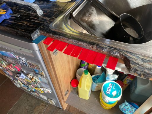 Craked granite worktop at the front. Plastic suppot bars put in to support the broken piece of granite, piece to be put backn in the gap.