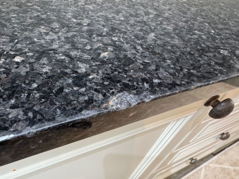 Before repair: chipped granite edges Damaged edge of the granite worktop with large chunks missing from the edge. This was due to things dropped on it, causing the chipped edges