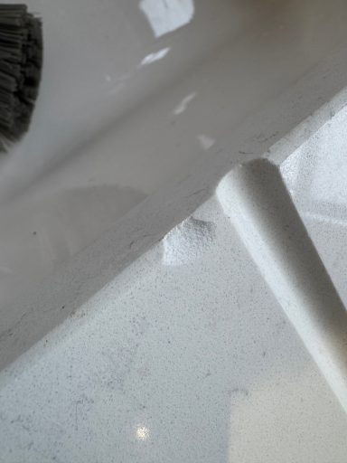 Marble effect quartz worktop chipped at the edge of the draining groove area. Dropped cup on the edge caused this damage to the quartz.