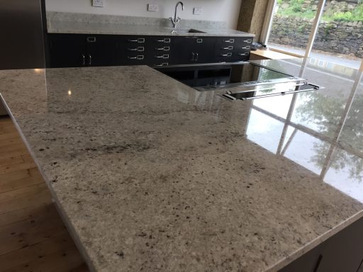 Granite Island bar with a high gloss shine finish. Natural granite island bar with hub Cut Out and Down drift in the surface, the surface was marked and scuffed. This needed fully restoring.
