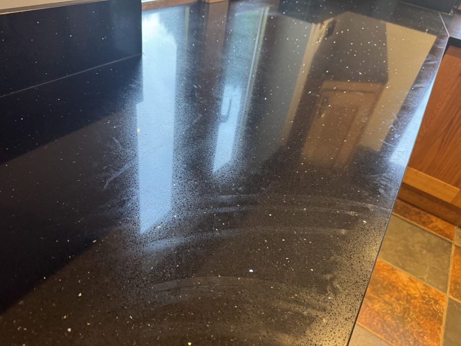 Before: dull black quartz Black quartz worktop in Highburton, Huddersfield before restoration, showing a dull and marked surface.