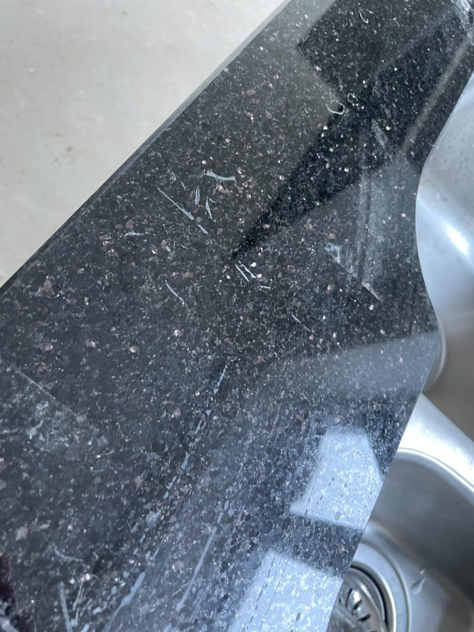Before restoration: scratched quartz surface Scuffed and damaged worktop in huddersfield.
