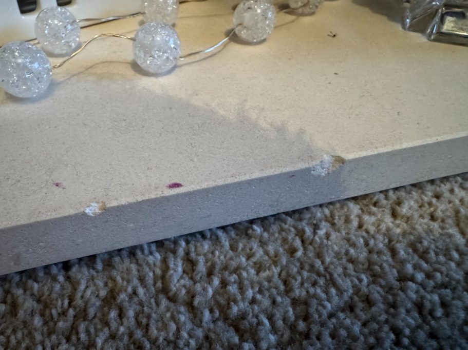 Before repair: chipped hearth edge Stone hearth with a chipped edge.