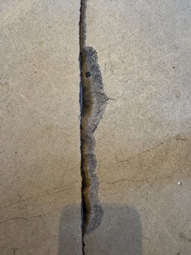 Limestone floor tile cracked across. This was due to floor dropping causing the floor tile to crack.