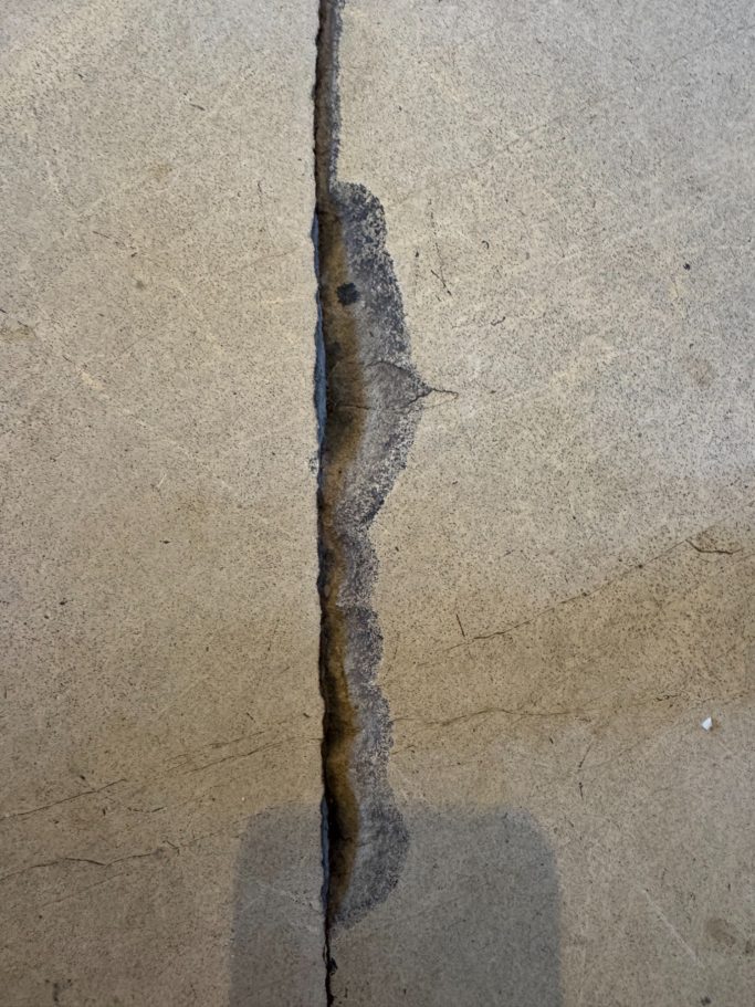 Before repair: cracked limestone floor tile Limestone floor tile cracked across. This was due to floor dropping causing the floor tile to crack.