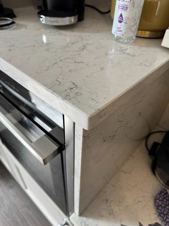 After repair: reshaped quartz corner Carrera White quartz worktop fully repaired at the corner where it was damaged by a large object.