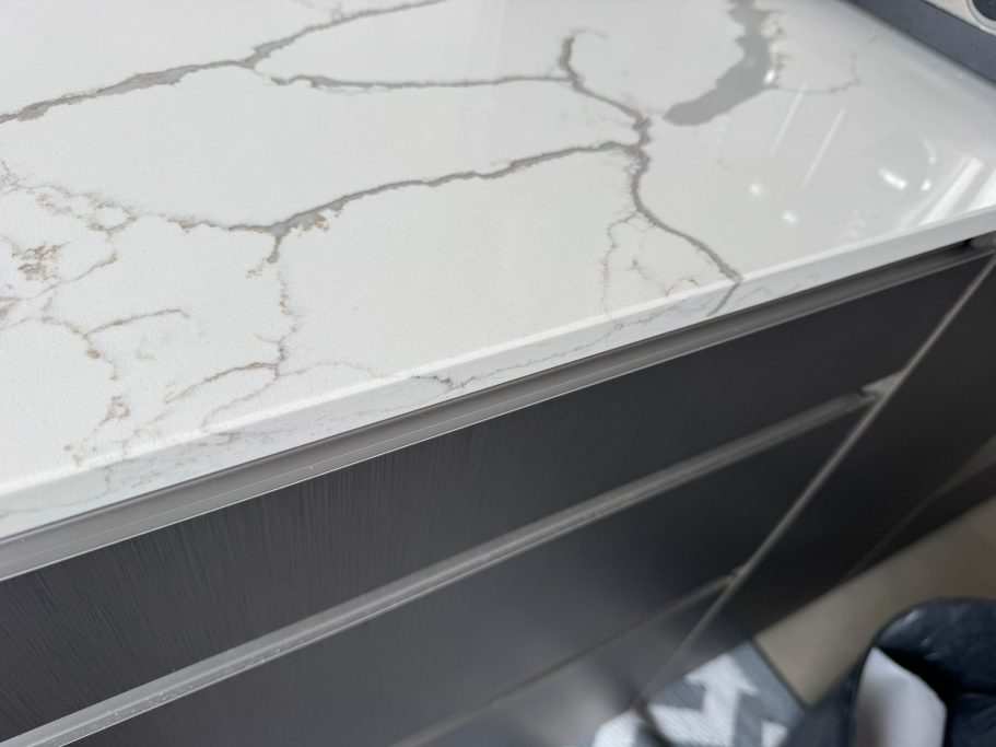 After repair: reshaped white quartz edge Picture of a white quartz worktop all finished and repaired, the edge was refilled with a resin and polished and shaped.