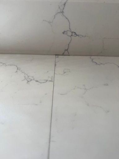"White quartz worktop joint showing a gap between the worktops." White course worked up called Carrera this Joint had dropped at the back causing a gap and the Joint to open up.