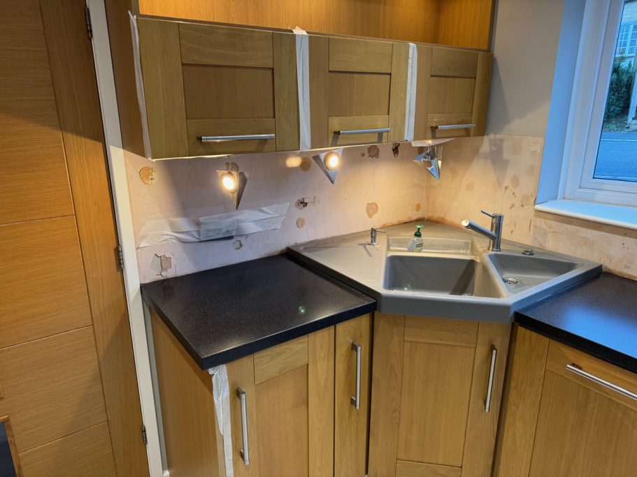 After restoration: Corian corner sink area Kitchen layout showing a corner sink made out of grey corian, all sanded to remove scratches and dints on the surface.