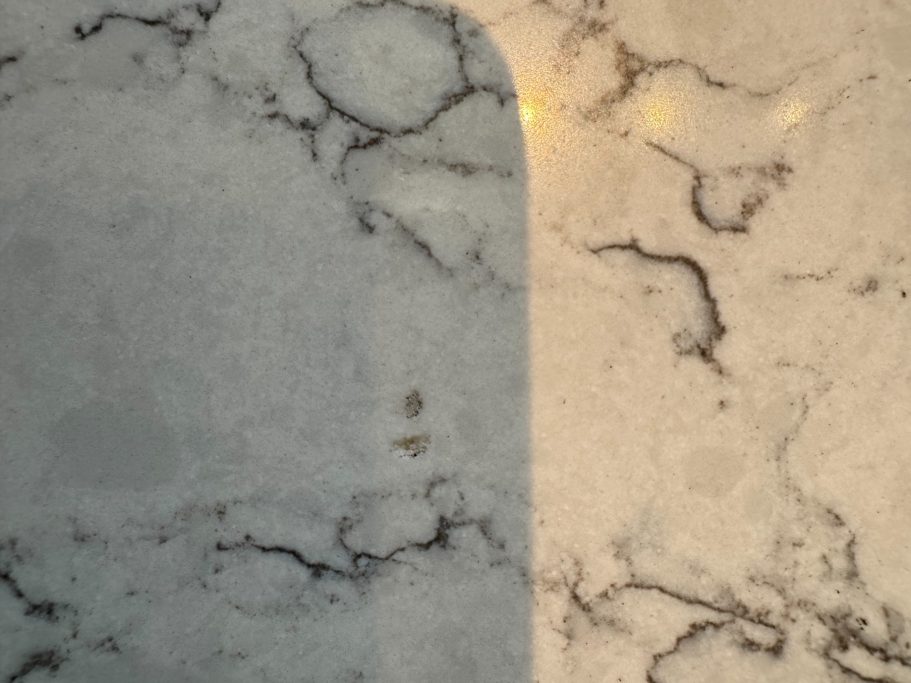 Before repair: damaged white quartz surface White quartz worktop with holes in the surface caused by large falling object damaging the worktop. This worktop is called Carrera White.