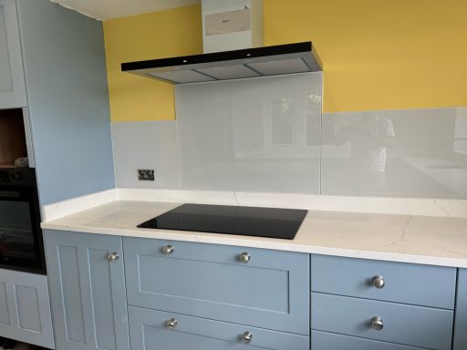 Carrera white quartz worktop at the hob area had originally tiles on the back wall, these were replaced by grey glass.