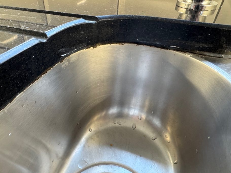 Before repair: deteriorated sink seal Silicone sealer all black and perished. Worktop repair in Emley, Huddersfield.