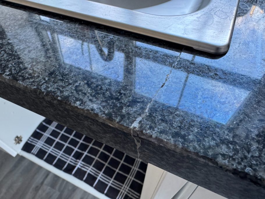 Before repair: cracked granite sink run Granite sink area with cracked granite worktop. Front of granite had no support causing the cracked granite worktop at the front.
