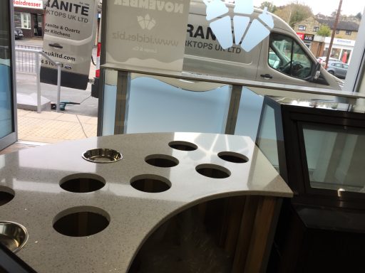 Curved white quartz worktop in a shop in Huddersfield. Holes in this quartz worktop were drilled on site, this was a ice cream parlour in Huddersfield, West Yorkshire.