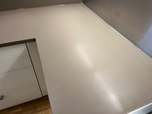 Light brown quartz worktop in a customers kitchen. Picture showing a full re-furbishment surface to the quartz top, removing the mark.