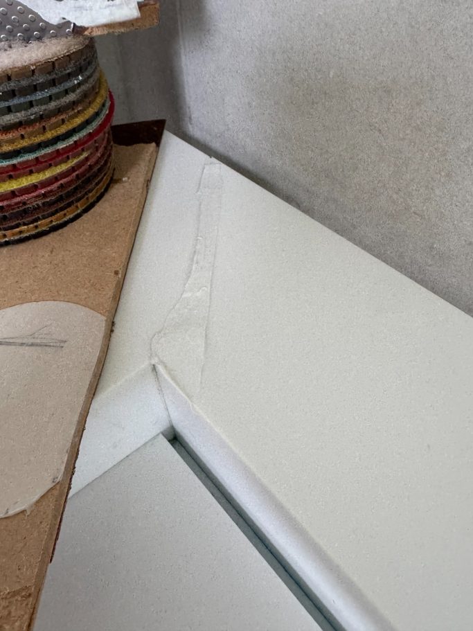 Corian vanity crack prepared for bonding White corian suface being prepared for new glue to fill the cracked surface before sanding.