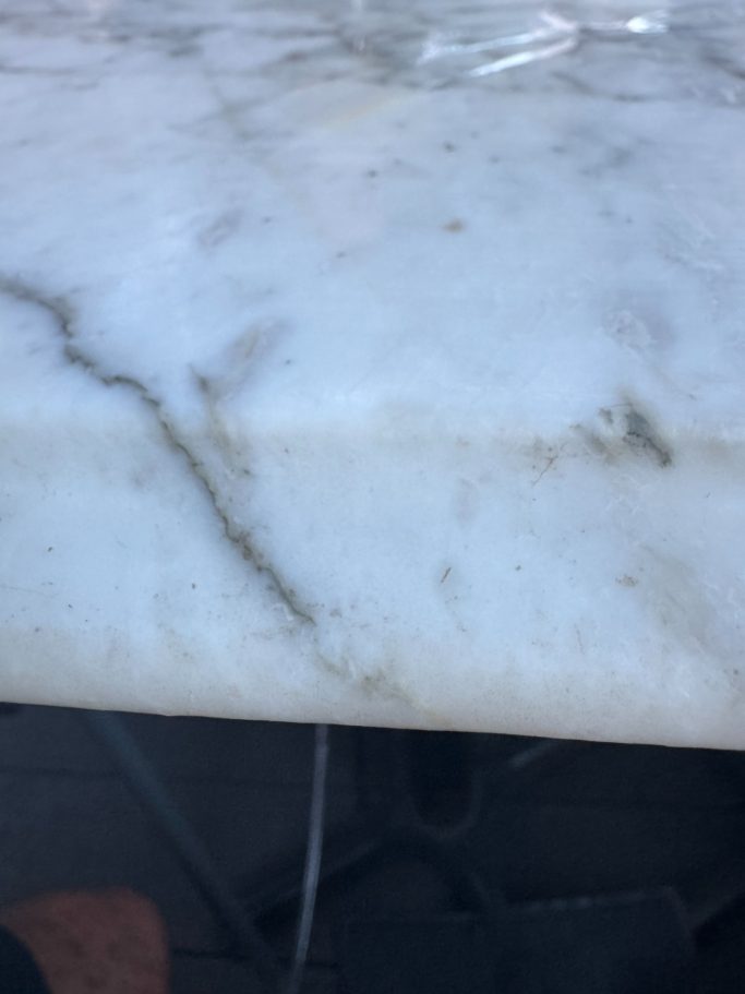 After repair: restored marble vanity edge "White marble vanity top with the repair to the edge; the piece was put back in and fully restored."