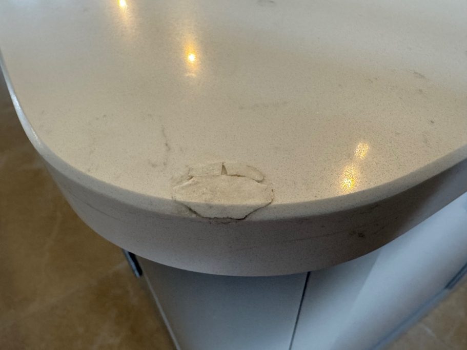 Before repair: damaged quartz island corner Quartz island corner showing an earlier repair requiring attention.