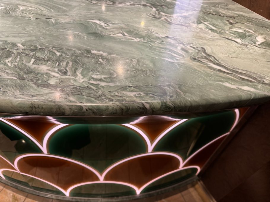 Decorative stone cocktail bar top Marble tabletop with a decorative scalloped edge in green, red, and white veins. Damaged worktop in huddersfield.
