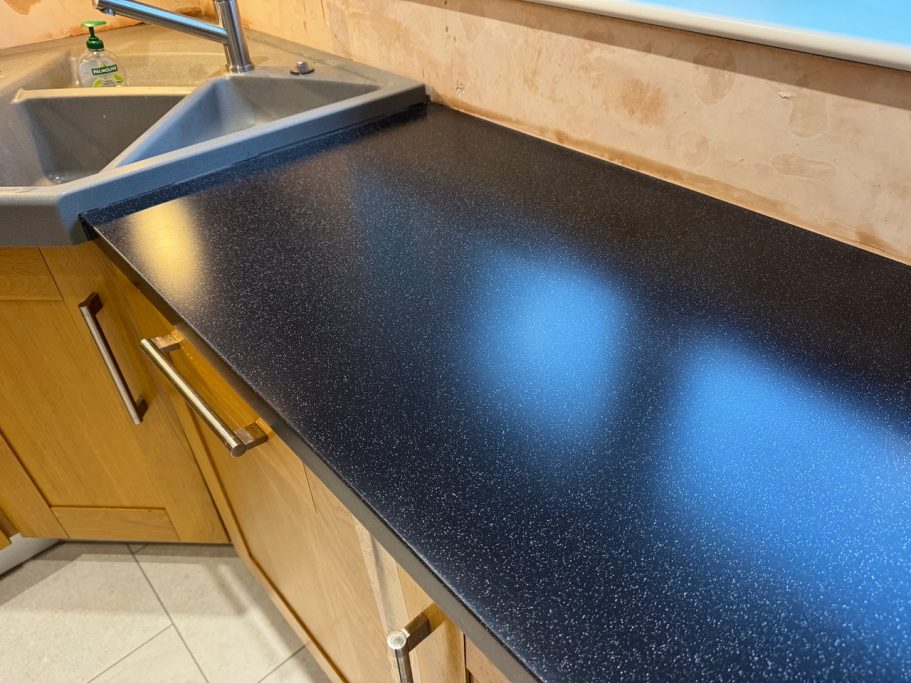 After restoration: refinished black Corian Black corian kitchen worktop re buffed to semi gloss finish, also edges repolished to match surface.