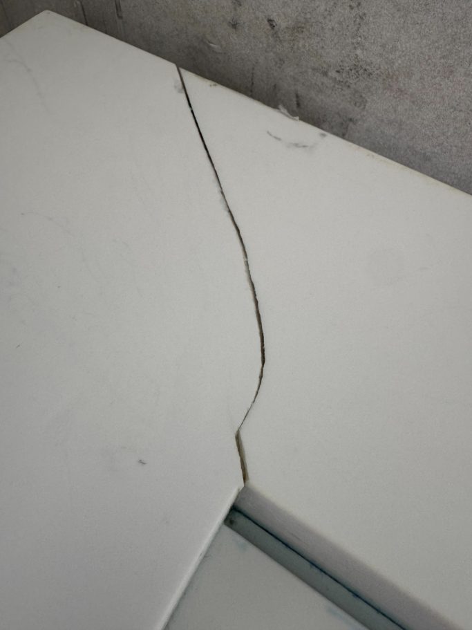 Before repair: cracked white Corian vanity top Corian cracked in corner of a bathroom vanity top. Job in harrogate area leeds.
