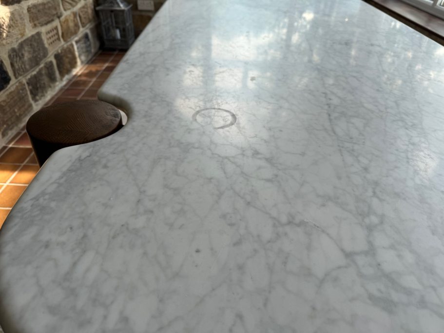 Before restoration: circular mark on marble White natural marble stained. Picture showing a ring mark from a coffee cup which stained the marble surface. This needed re-polishing.