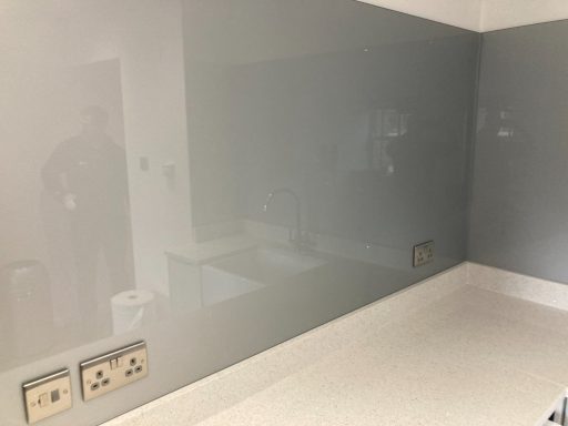 30mm quartz worktops with a grey glass splash back against the wall.  The glass was sat on the quartz to stop food splashes on the wall.
