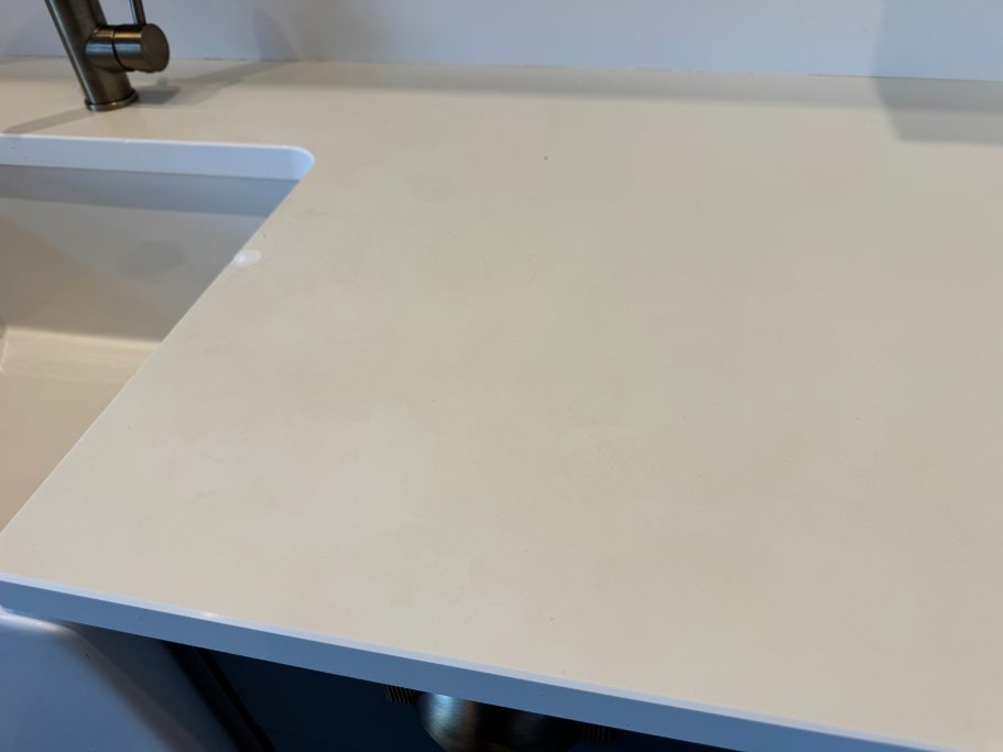 Before restoration: discoloured white quartz White quartz worktop before the Repair showing stained and discoloured surface. The worktop had a yellow tinge to it.