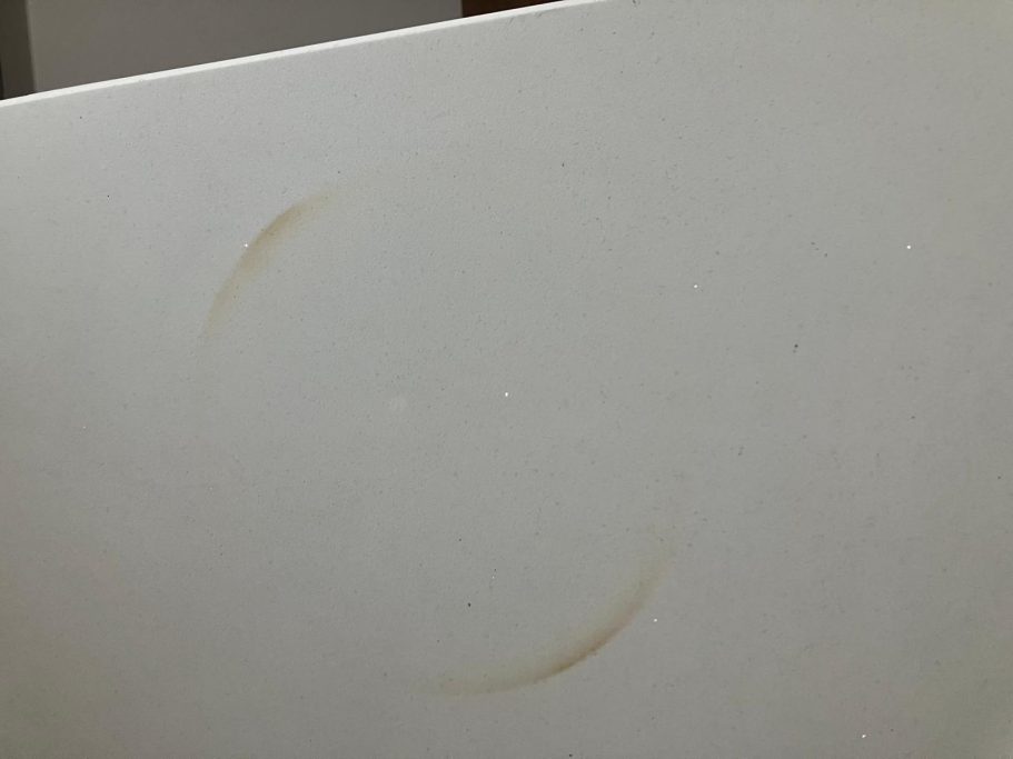 Before repair: heat mark on quartz Quartz worktop burnt on the surface with a red hot pan from a gas hob. A circle shows the burnt quartz top. This needs re-sanding .