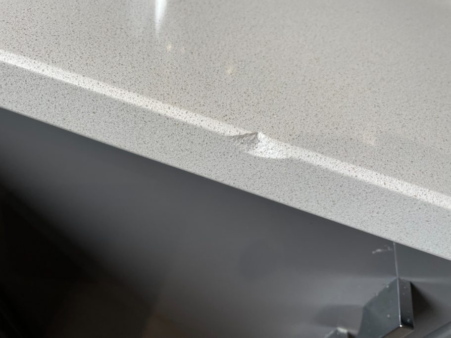 Before repair: chipped white quartz in Pudsey Chunk of quartz missing on the edge of the worktop in pudsey west yorkshire