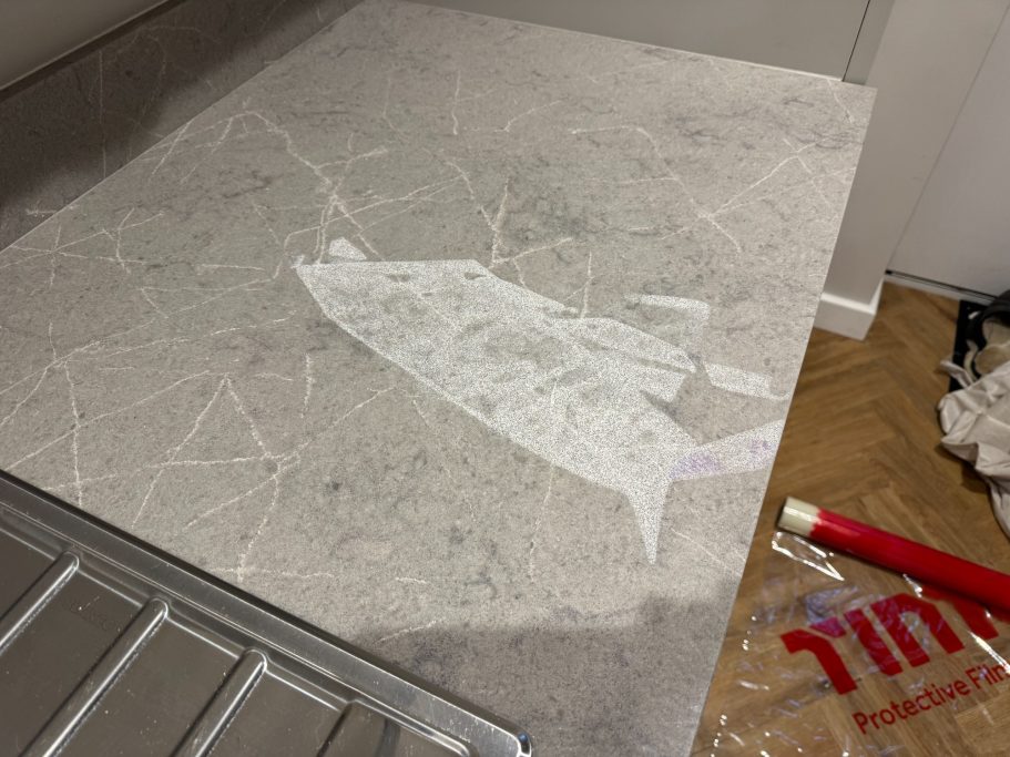 Before restoration: cleaning-product damage to quartz Quartz surface damaged by a cleaning product before restoration.