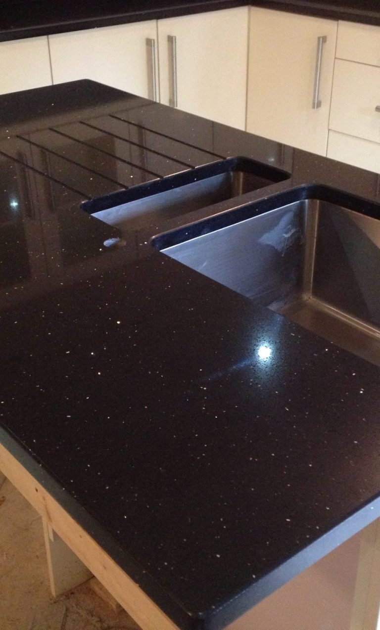 Granite island bar fitted in huddersfield. Black granite with a gold fleck of copper. Stainless steal bowls undermounted .Polished cut outs.
