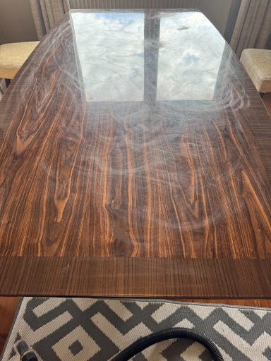 Dining table full of scratches and round scuff marks, also picture showing scuffs and chips in the circles areas. Resin dining table which was purchased from Christopher Pratts after a few years the surface become scratched and stained.