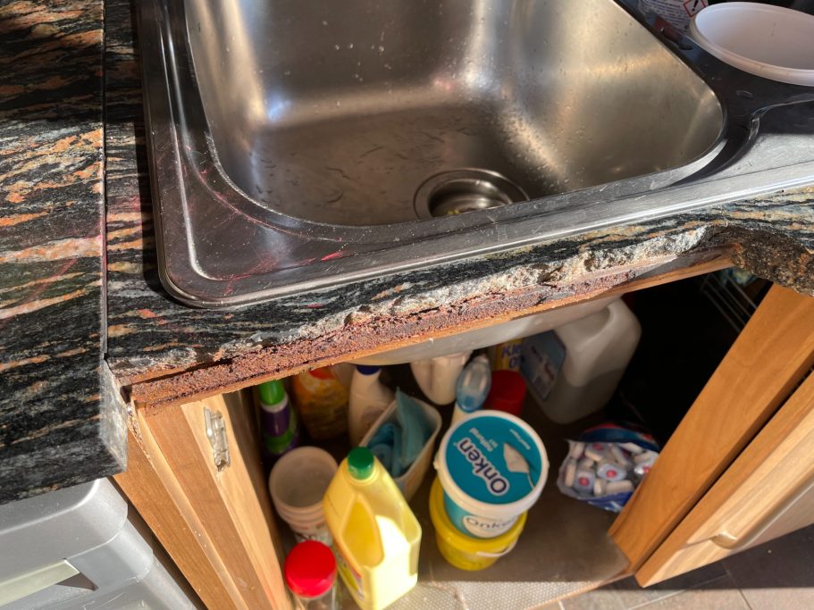 Before repair: missing granite section and rust damage A granite worktop sink area showing rust at the front of the worktop with the piece missing , this had dropped out because of water damage.