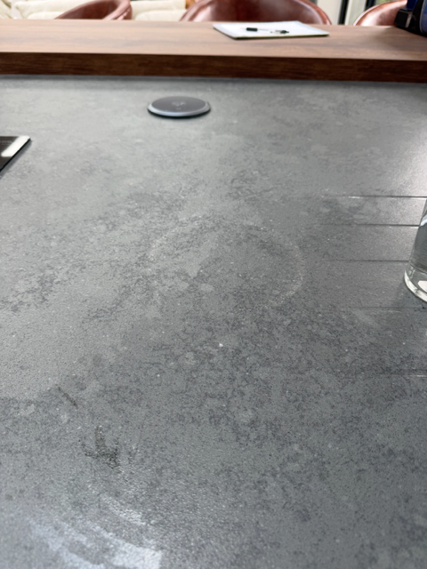 Before restoration: circular heat mark on granite "Granite worktop island bar with a burnt circle mark on the surface; this was caused by a red-hot pan left on the surface."