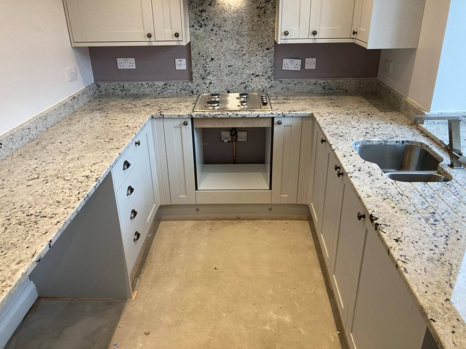 New Venetian Gold granite installation U shaped kitchen worktop in natural granite with undermounted sink and hob cut out.Splash back behind hob up to units full height in leeds.