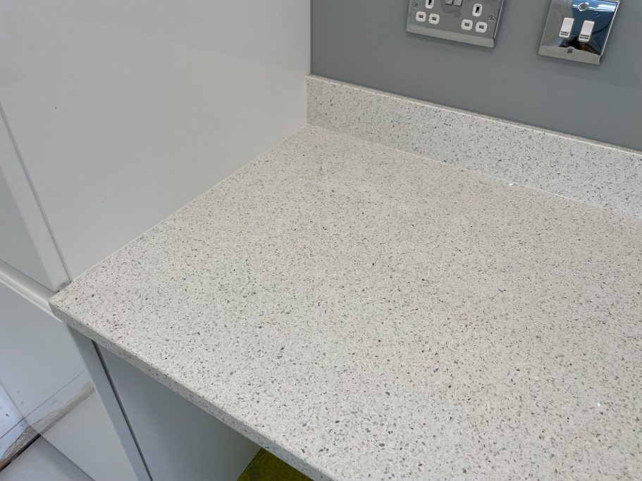After repair: levelled white quartz worktop Picture of a fully restored white quartz worktop. Worktop was lifted underneath to meet the upstand which was still glued to the wall.