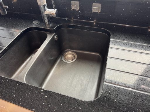 A stainless steel bowl in a black worked top needed restoring. Sparkly black Silestone kitchen worktop fully repolished